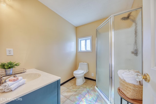 full bath with toilet, vanity, baseboards, tile patterned floors, and a stall shower