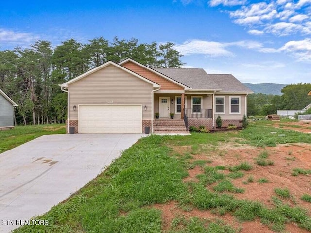 ranch-style house featuring covered porch, an attached garage, and concrete driveway