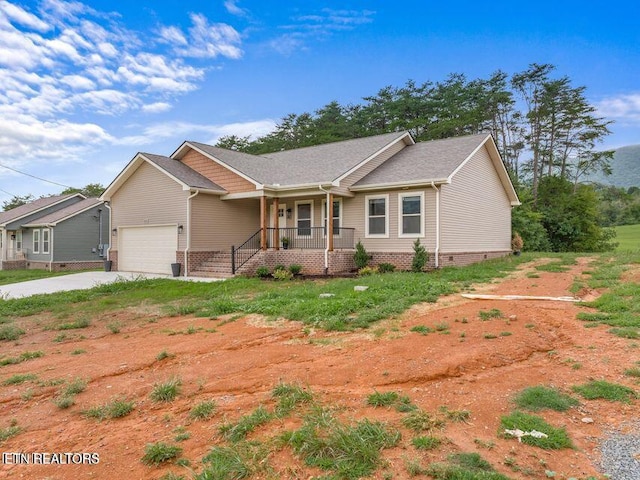 ranch-style house with a porch, driveway, and a garage