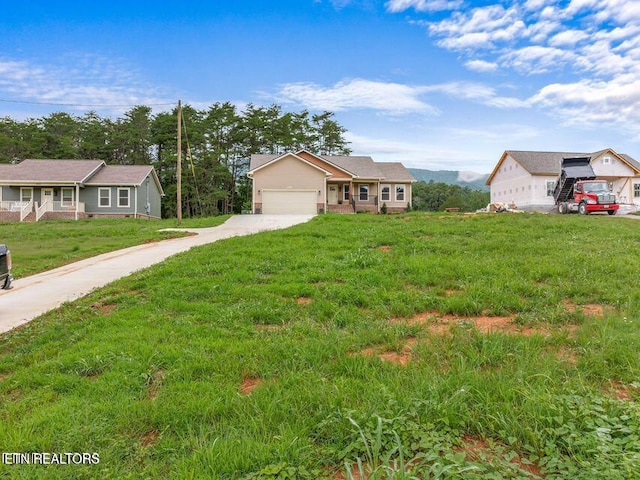 view of front of property featuring a garage, concrete driveway, and a front yard