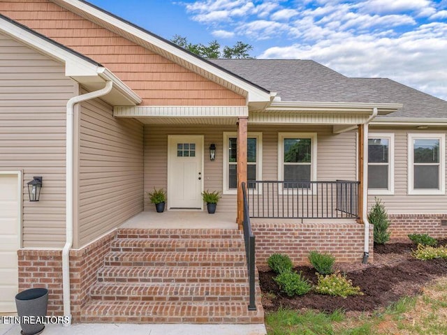 property entrance featuring a garage, a porch, and roof with shingles