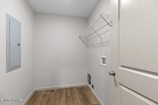 washroom with hookup for a washing machine, laundry area, wood finished floors, baseboards, and electric panel