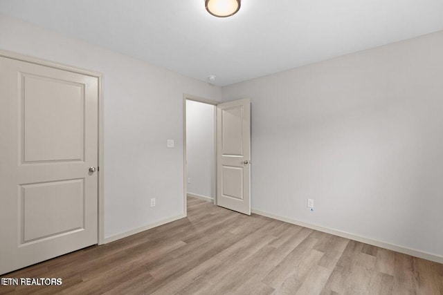 unfurnished bedroom featuring baseboards and wood finished floors