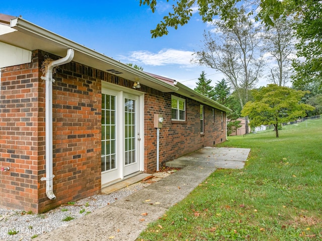 view of home's exterior with a yard and brick siding