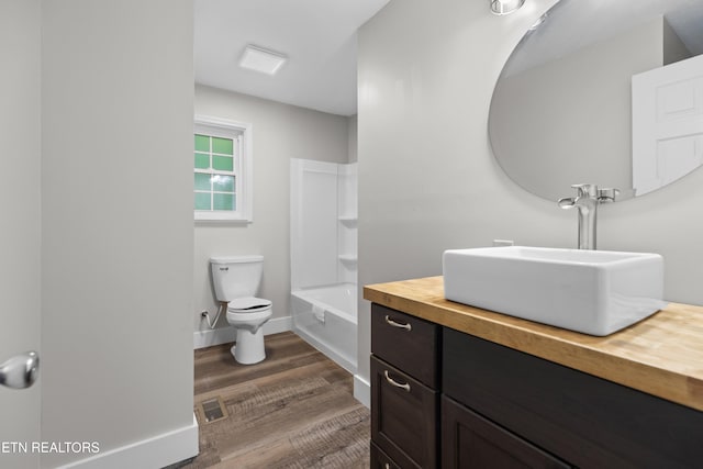 full bath featuring baseboards, visible vents, toilet, wood finished floors, and vanity