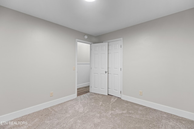 unfurnished bedroom featuring carpet floors, a closet, and baseboards