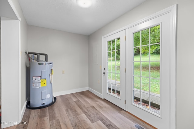 utilities featuring visible vents and electric water heater