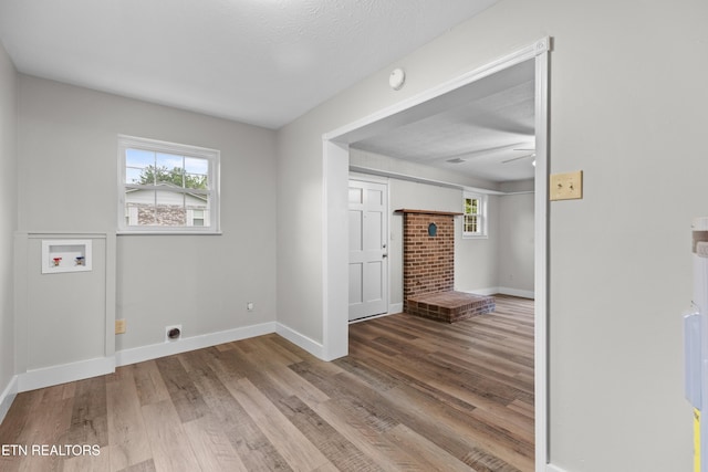 laundry area featuring a healthy amount of sunlight, hookup for a washing machine, laundry area, and wood finished floors