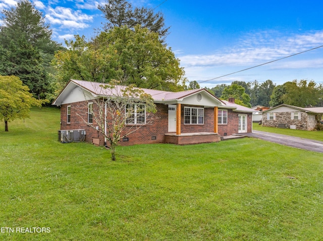 view of front of house featuring driveway, crawl space, cooling unit, a front lawn, and brick siding