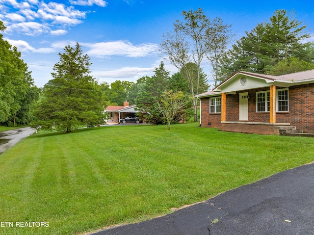 view of yard featuring a carport and covered porch