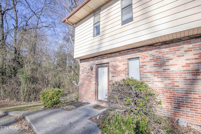 view of exterior entry featuring brick siding