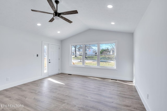 entryway featuring lofted ceiling, recessed lighting, wood finished floors, and baseboards