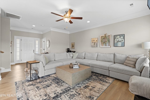 living area featuring crown molding, visible vents, wood finished floors, and recessed lighting