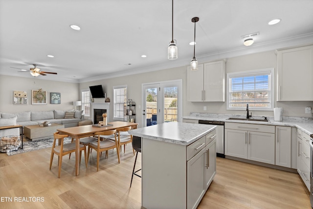 kitchen with crown molding, a fireplace, visible vents, a sink, and dishwasher