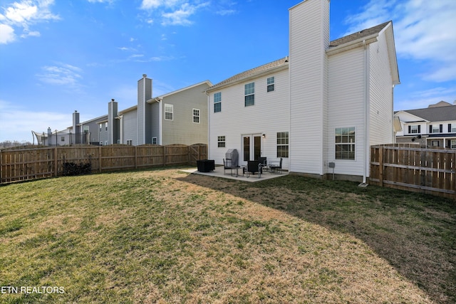 back of house with a yard, a fenced backyard, a chimney, and a patio