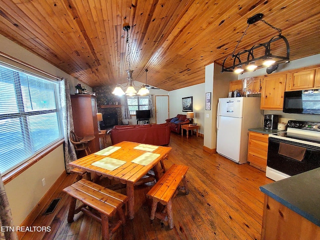 dining room with visible vents, lofted ceiling, wood ceiling, hardwood / wood-style floors, and a stone fireplace