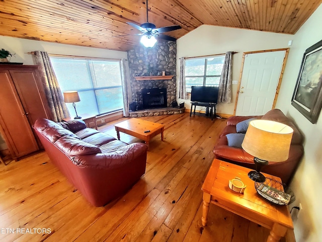 living area with light wood-type flooring, wood ceiling, a fireplace, and vaulted ceiling