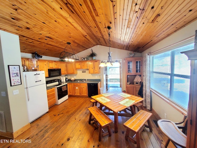 kitchen featuring lofted ceiling, a sink, light wood-type flooring, black appliances, and a wealth of natural light