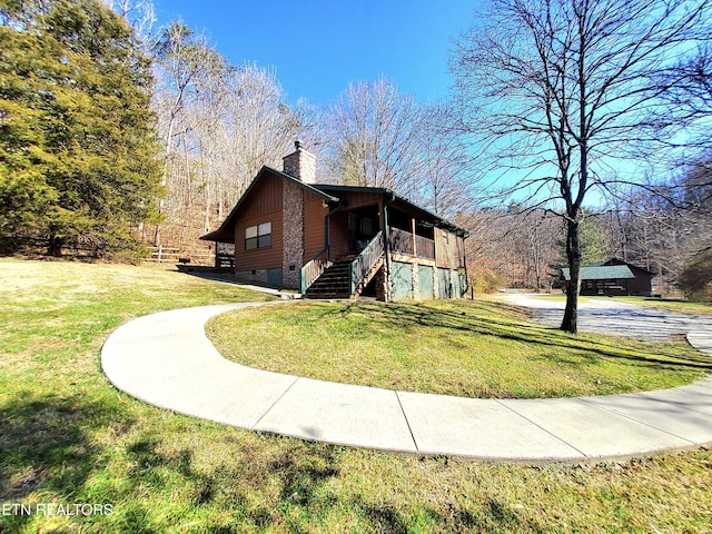 view of side of property with stairs, a yard, crawl space, and a chimney