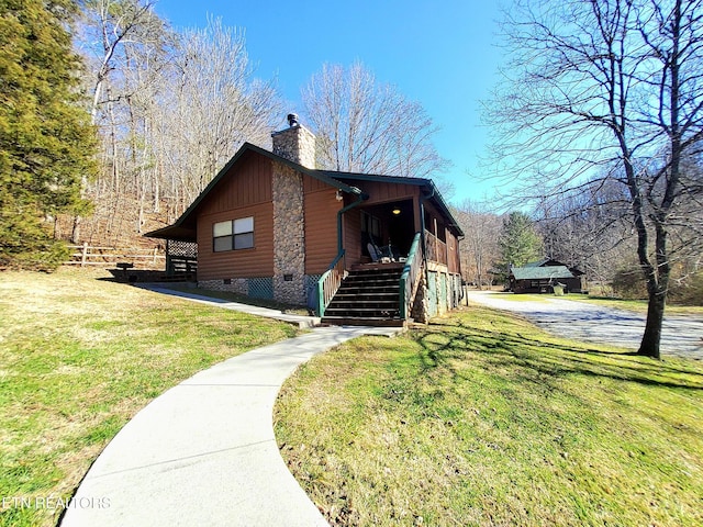 exterior space featuring crawl space, stairs, a chimney, and a front yard