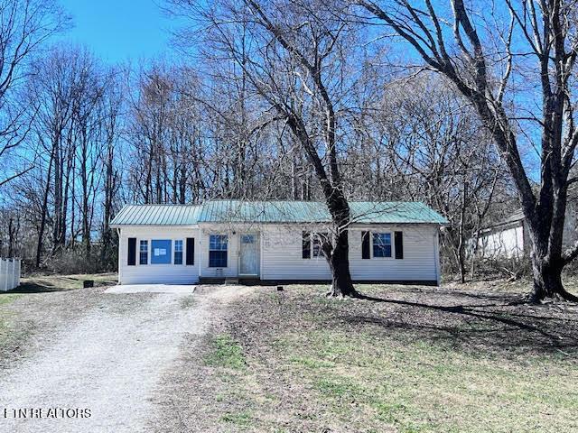 view of front of home featuring driveway and metal roof