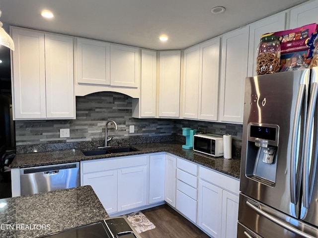 kitchen featuring stainless steel appliances, tasteful backsplash, a sink, and white cabinets