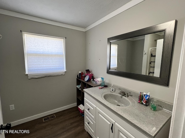 full bath with baseboards, visible vents, wood finished floors, a textured ceiling, and vanity