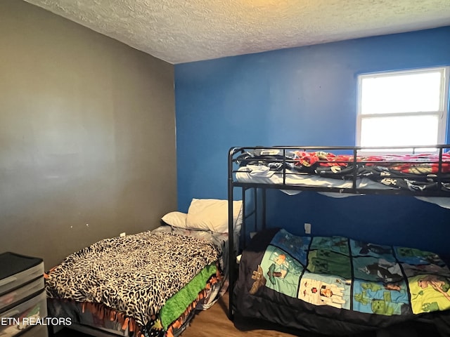 bedroom featuring a textured ceiling and wood finished floors