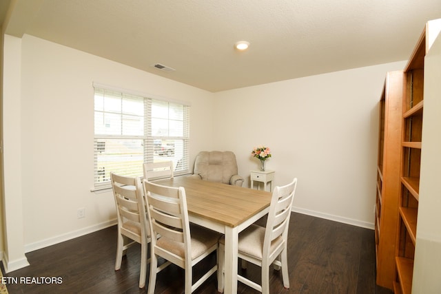 dining room featuring dark wood-style floors, visible vents, and baseboards