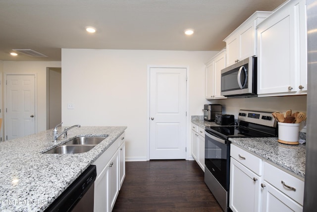 kitchen with visible vents, white cabinets, dark wood-type flooring, stainless steel appliances, and a sink