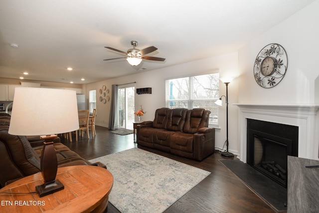 living area with ceiling fan, recessed lighting, dark wood-type flooring, a fireplace, and baseboards