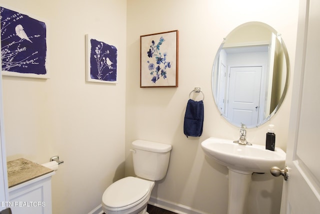 half bathroom featuring toilet and baseboards