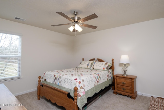 bedroom with light colored carpet, visible vents, ceiling fan, and baseboards