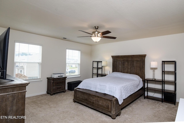 bedroom featuring visible vents, a ceiling fan, light carpet, a textured ceiling, and baseboards