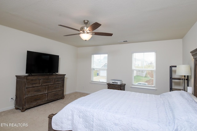 bedroom with light colored carpet, visible vents, baseboards, and multiple windows