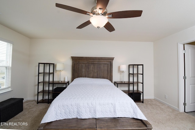 carpeted bedroom with ceiling fan and baseboards