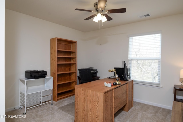 office space with baseboards, visible vents, a ceiling fan, and light colored carpet