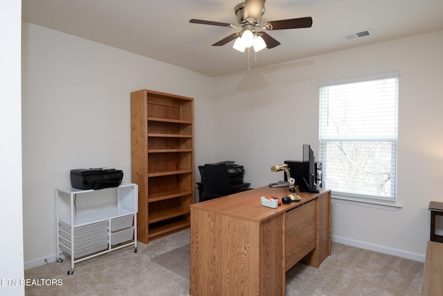 home office with light carpet, plenty of natural light, visible vents, and a ceiling fan