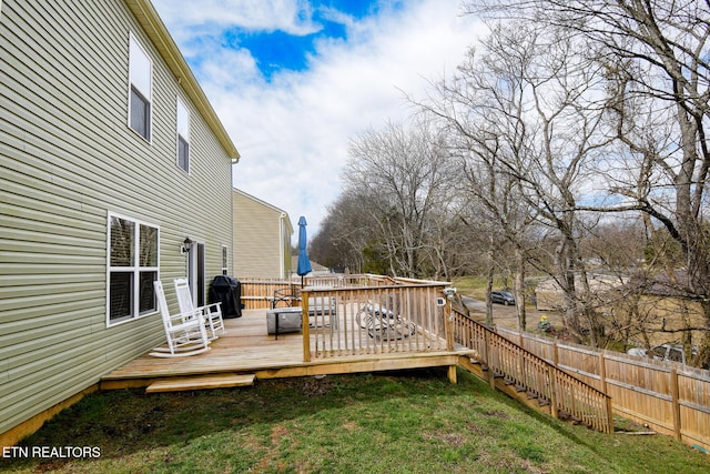 deck with a grill, fence, and a yard