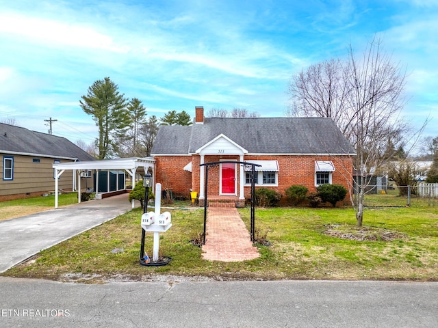 view of front of house featuring a front yard, a chimney, fence, and brick siding