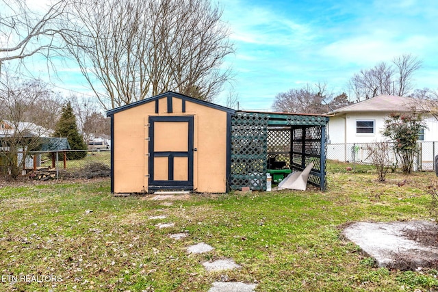 view of outbuilding featuring fence and an outbuilding