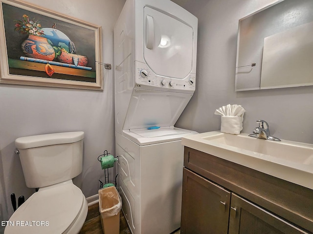 clothes washing area with stacked washer / dryer, laundry area, and a sink