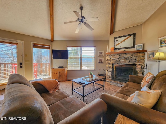 carpeted living room featuring vaulted ceiling with beams, a fireplace, a textured ceiling, and a ceiling fan