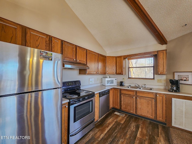 kitchen with vaulted ceiling with beams, under cabinet range hood, a sink, visible vents, and appliances with stainless steel finishes