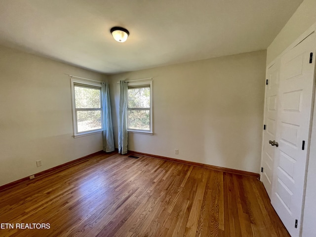 empty room with wood finished floors and baseboards