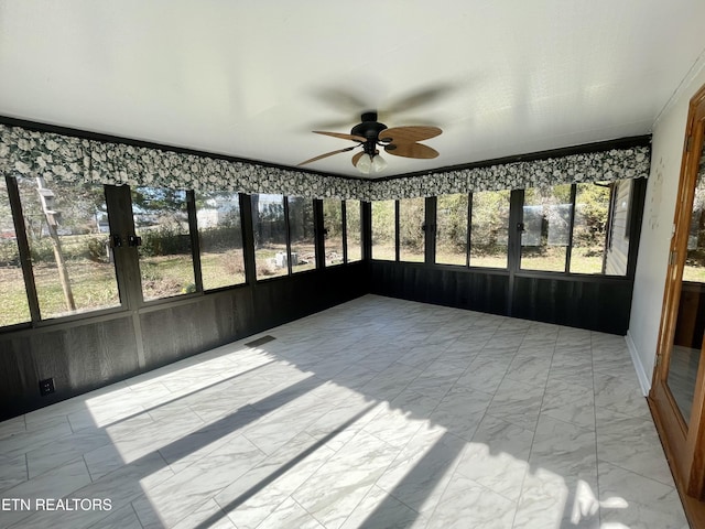 unfurnished sunroom with visible vents and ceiling fan