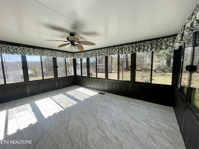 unfurnished sunroom with a ceiling fan and visible vents