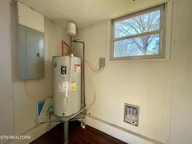 utility room with electric panel and water heater