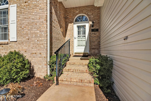 doorway to property with brick siding