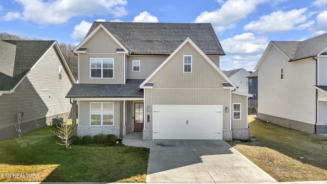 view of front facade with driveway, stone siding, a front yard, and roof with shingles